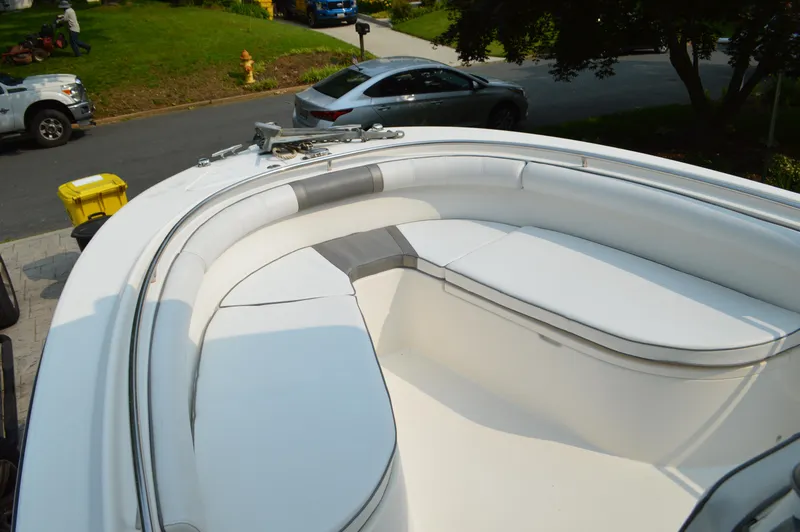 Slide: The Image of 2007 Edgewater 228CC boat with white seating, parked on a residential street. - 30