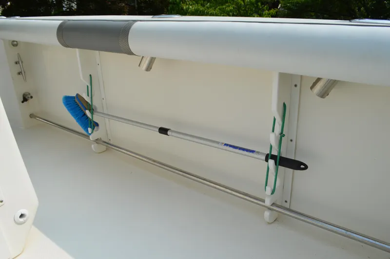 Slide: The Image of 2007 Edgewater 228CC boat interior with mounted cleaning brush and rod holders. - 34