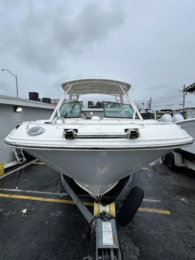 Slide: The Image of 2018 Boston Whaler 230 Vantage boat on trailer, parked outdoors on a cloudy day. - 2