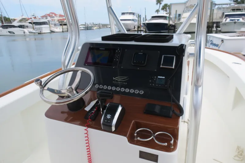 Slide: The Image of Valentino 28CC boat dashboard, 2022 model, featuring steering wheel and navigation controls at marina. - 26