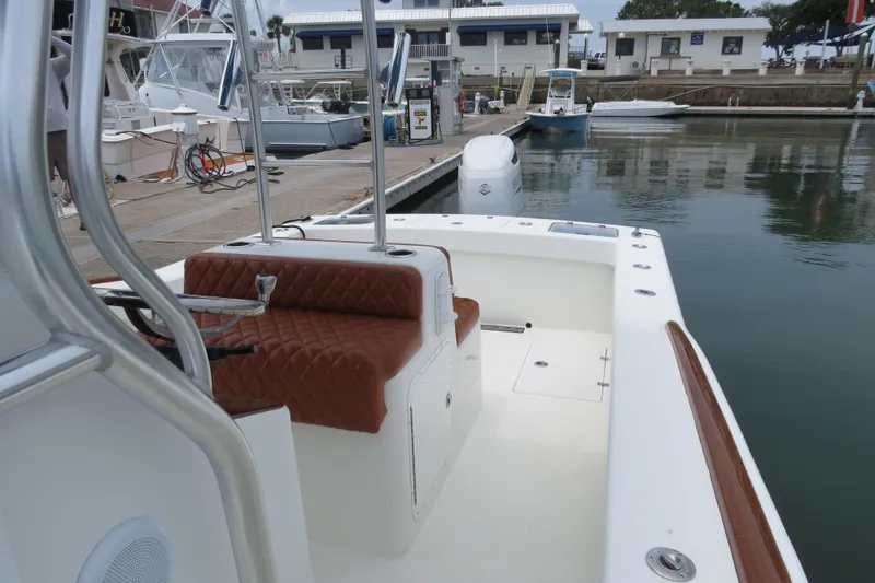 Slide: The Image of 2022 Valentino 28CC boat with brown seating at a marina dock. - 30