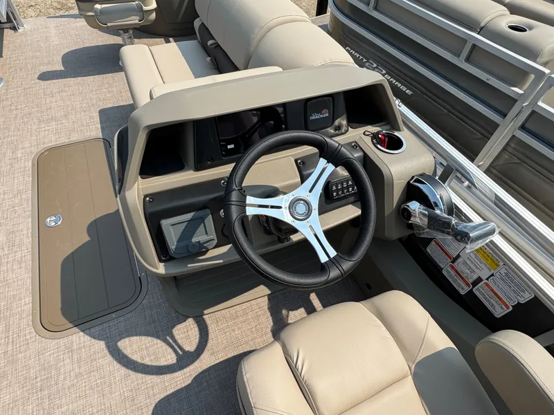 Slide: The Image of 2025 Sun Tracker Fishin' Barge 22 XP3 steering console with beige seating and controls. - 12