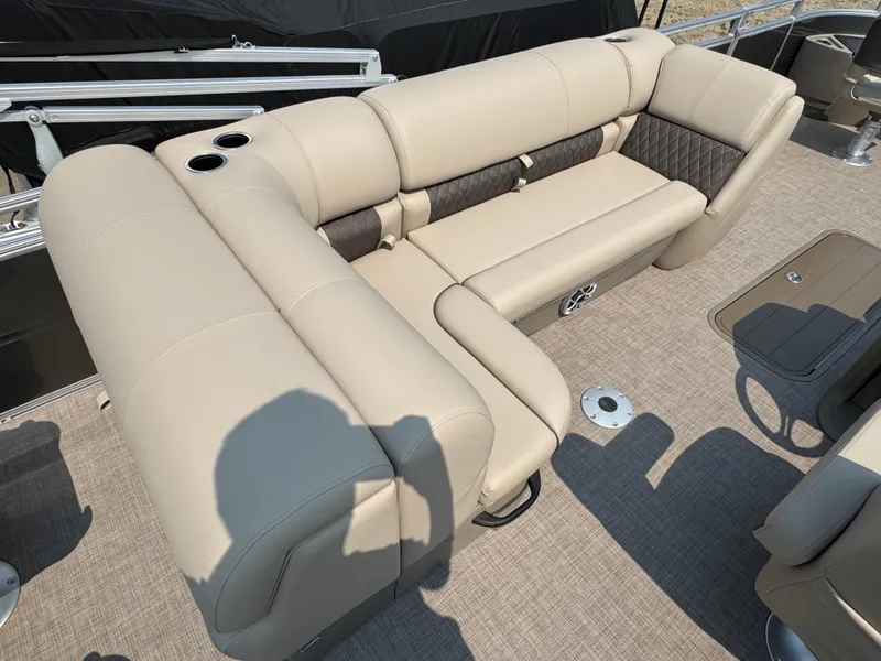 Slide: The Image of 2025 Sun Tracker Fishin' Barge 22 XP3 interior with beige seating and cup holders. - 16