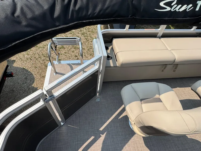 Slide: The Image of 2025 Sun Tracker Fishin' Barge 22 XP3 interior with beige seating and metal railings. - 18
