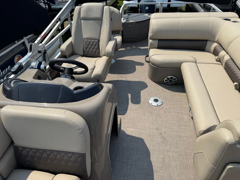 Slide: The Image of 2023 Sun Tracker Fishin' Barge 20 DLX interior with beige seating and steering console. - 10