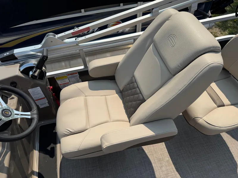 Slide: The Image of 2023 Sun Tracker Fishin' Barge 20 DLX captain's chair with beige upholstery and steering wheel. - 13