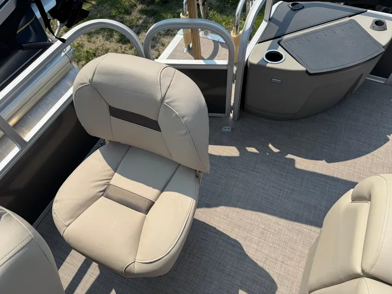 Slide: The Image of 2023 Sun Tracker Fishin' Barge 20 DLX interior with beige seating and console. - 14