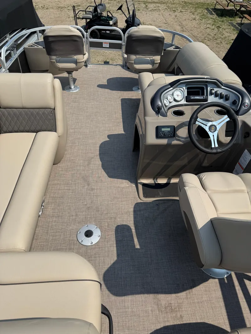 Slide: The Image of 2023 Sun Tracker Fishin' Barge 20 DLX interior with beige seating and modern dashboard. - 17