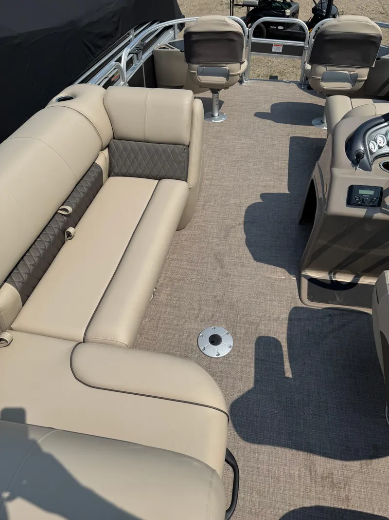 Slide: The Image of 2023 Sun Tracker Fishin' Barge 20 DLX interior with beige seating and modern dashboard. - 18