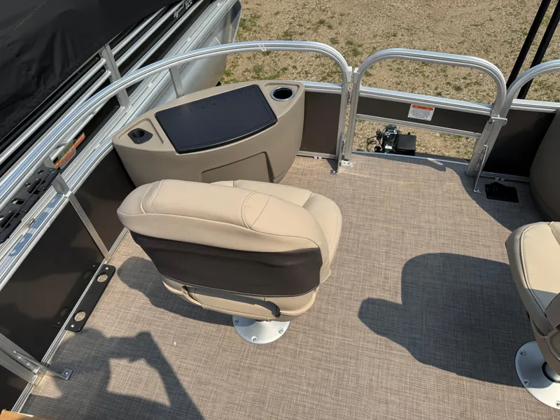 Slide: The Image of 2023 Sun Tracker Fishin' Barge 20 DLX interior with beige seating and control panel. - 8