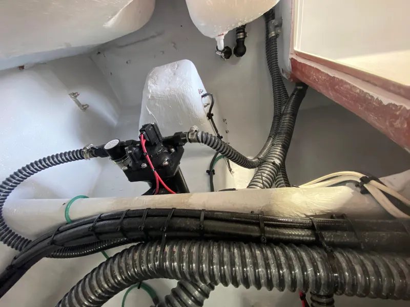 Slide: The Image of Interior view of 2026 Reef Runner 230 boat showing wiring and plumbing components. - 12