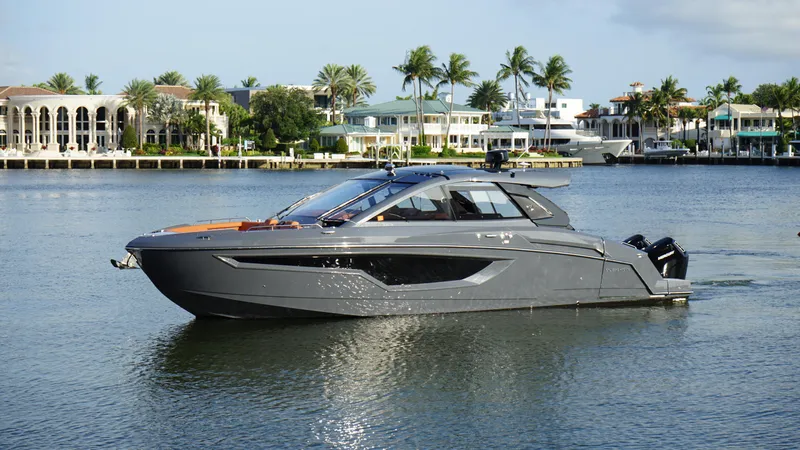 Slide: The Image of 2023 Cruisers Yachts 42 GLS OB on calm water, luxury waterfront homes in background. - 22