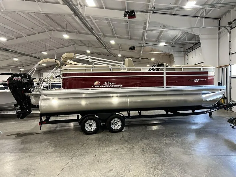 The Image of 2025 Sun Tracker PARTY BARGE® 22 RF DLX pontoon boat in a showroom. - 1