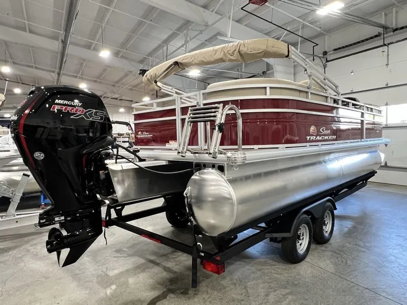 Slide: The Image of 2025 Sun Tracker PARTY BARGE® 22 RF DLX pontoon boat in showroom, featuring Mercury engine. - 3