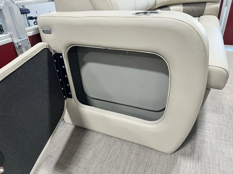 Slide: The Image of 2025 Sun Tracker PARTY BARGE® 22 RF DLX storage compartment with beige upholstery and cup holder. - 9