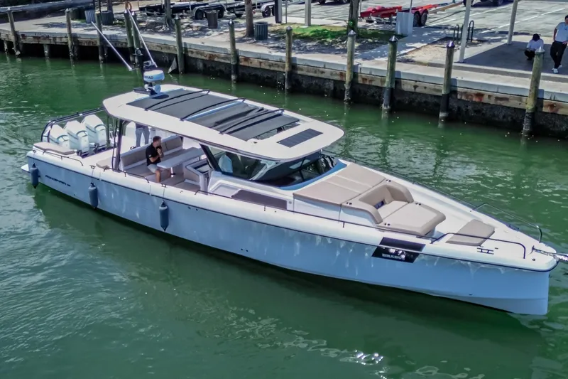 The Image of 2026 Axopar 45 Cross Top luxury boat docked in marina, featuring sleek design and spacious seating. - 0