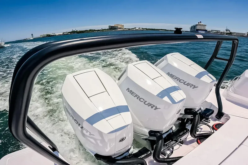 Slide: The Image of 2026 Axopar 45 Cross Top with triple Mercury engines cruising on open water. - 10