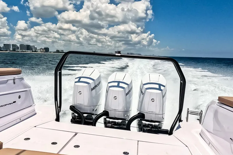 Slide: The Image of 2026 Axopar 45 Cross Top boat with triple Mercury engines cruising on open water. - 11