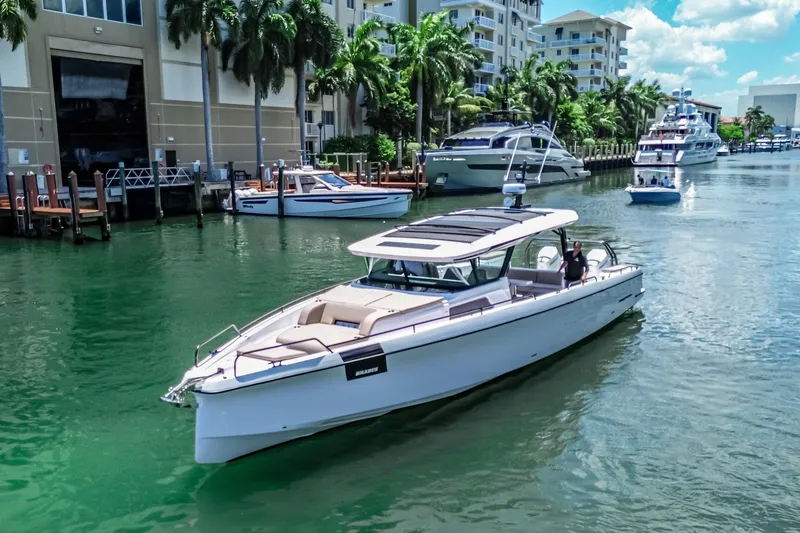 Slide: The Image of 2026 Axopar 45 Cross Top boat cruising in a scenic marina with palm trees. - 2