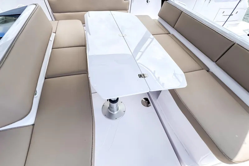 Slide: The Image of Interior of 2026 Axopar 45 Cross Top with beige seating and white table. - 26