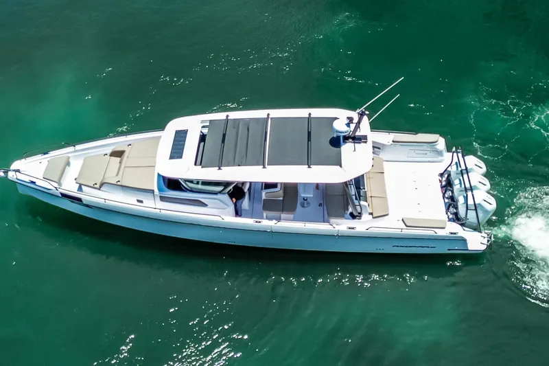 Slide: The Image of 2026 Axopar 45 Cross Top boat cruising on clear turquoise water. - 3