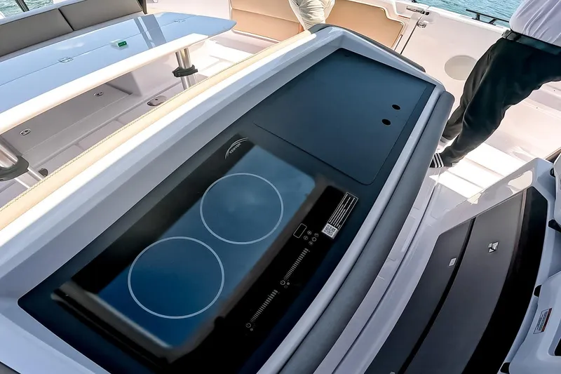 Slide: The Image of 2026 Axopar 45 Cross Top boat interior with modern stovetop and seating area. - 33