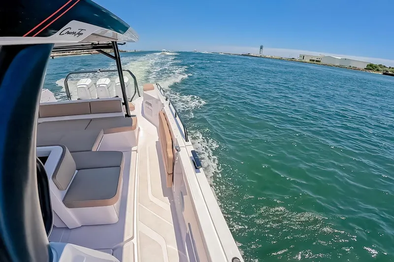 Slide: The Image of 2026 Axopar 45 Cross Top cruising on open water under clear blue skies. - 42