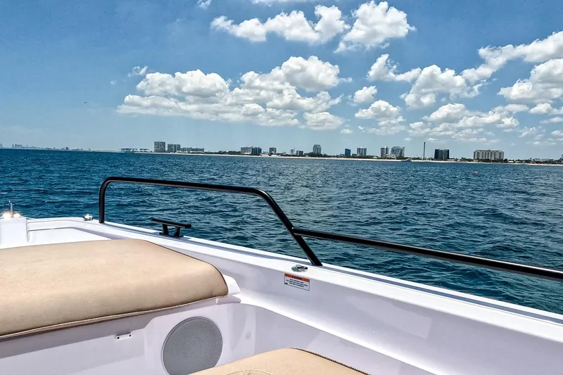 Slide: The Image of 2026 Axopar 45 Cross Top boat on open water with city skyline in background. - 47