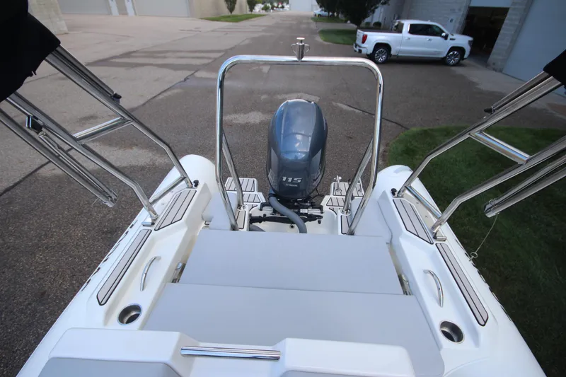 Slide: The Image of 2025 Zodiac Medline 5.8 NEO boat with 115hp engine, rear view, parked outdoors. - 10