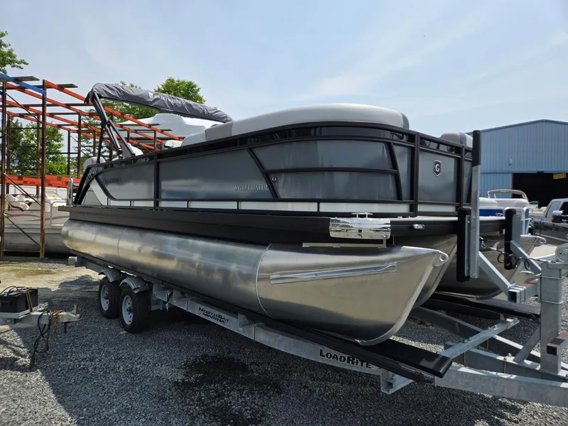 The Image of 2026 Godfrey Sweetwater 2286 QS pontoon boat on trailer, parked outdoors. - 0