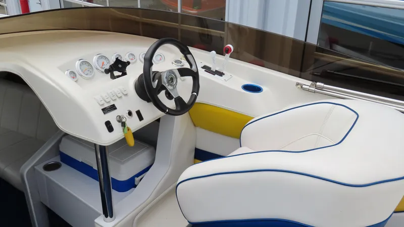 Slide: The Image of 2002 Nordic 28 Heat boat interior with white and blue seating, steering wheel, and dashboard controls. - 11