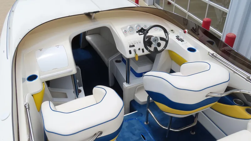 Slide: The Image of Interior of 2002 Nordic 28 Heat boat with white and blue seating, steering wheel, and dashboard. - 13