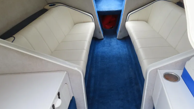 Slide: The Image of Interior of 2002 Nordic 28 Heat boat with white seating and blue carpet. - 15