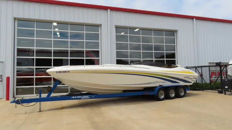 Slide: The Image of 2002 Nordic 28 Heat boat on trailer, parked outside a garage with glass doors. - 3