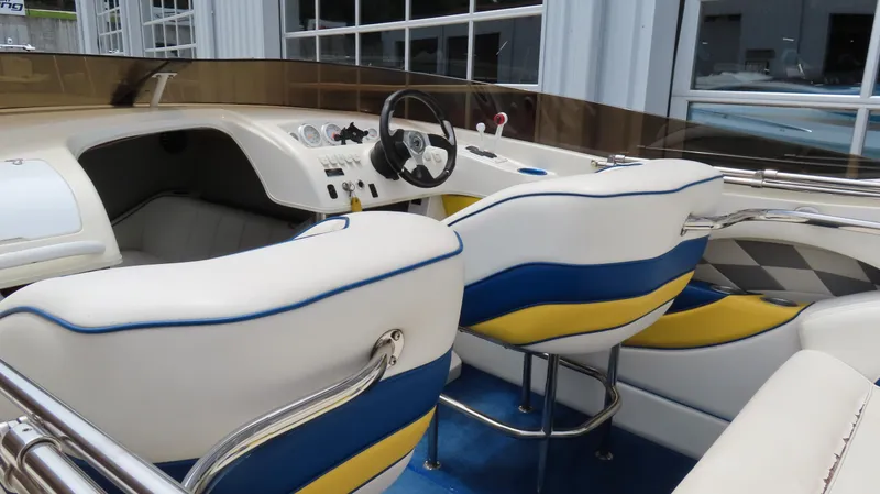 Slide: The Image of Interior of a 2002 Nordic 28 Heat boat with white, blue, and yellow seating. - 5