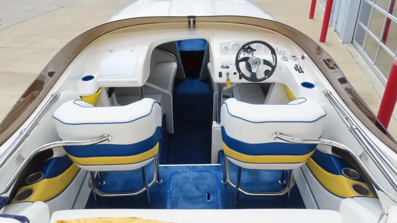 Slide: The Image of 2002 Nordic 28 Heat boat interior with white, blue, and yellow seating, and steering wheel. - 7