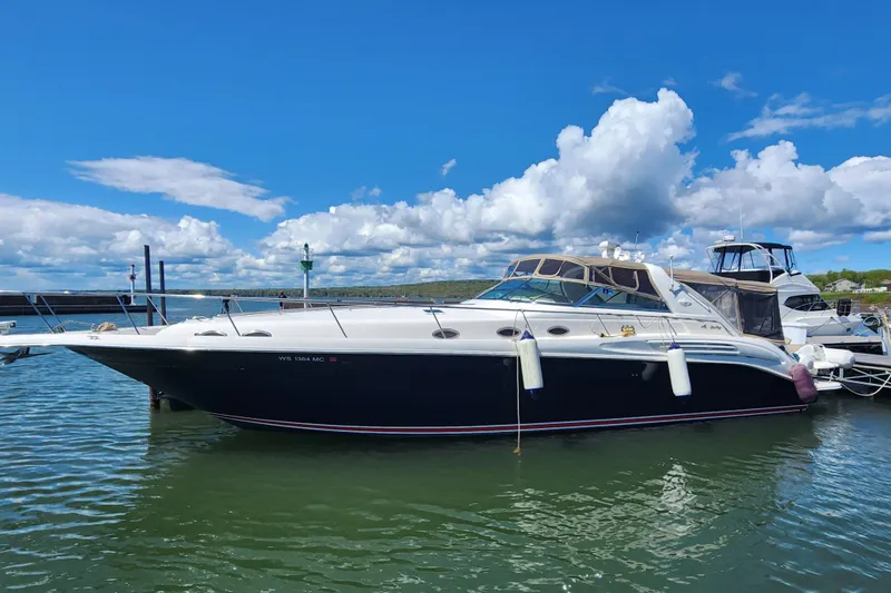 The Image of 1997 Sea Ray 450 yacht docked on a sunny day with blue skies and clouds. - 0