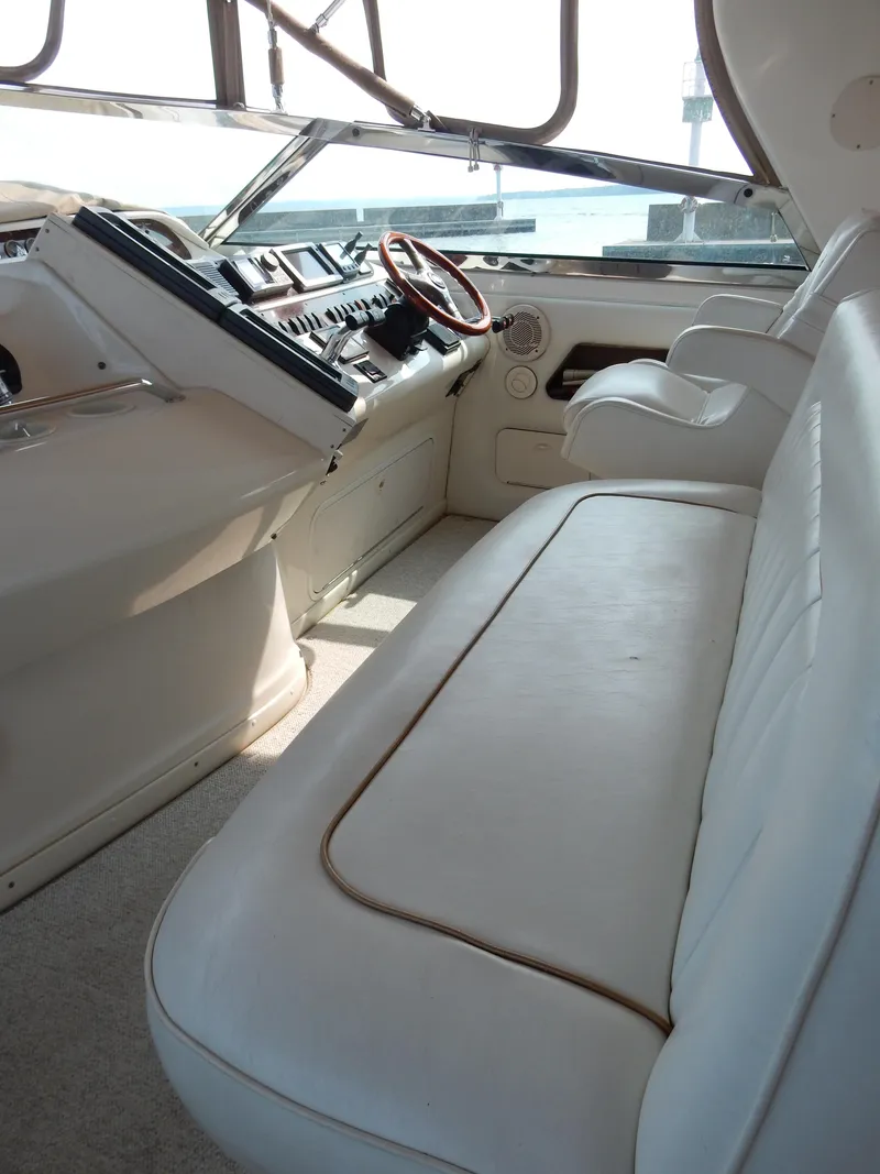 Slide: The Image of 1997 Sea Ray 450 yacht cockpit with white seating and control panel. - 12