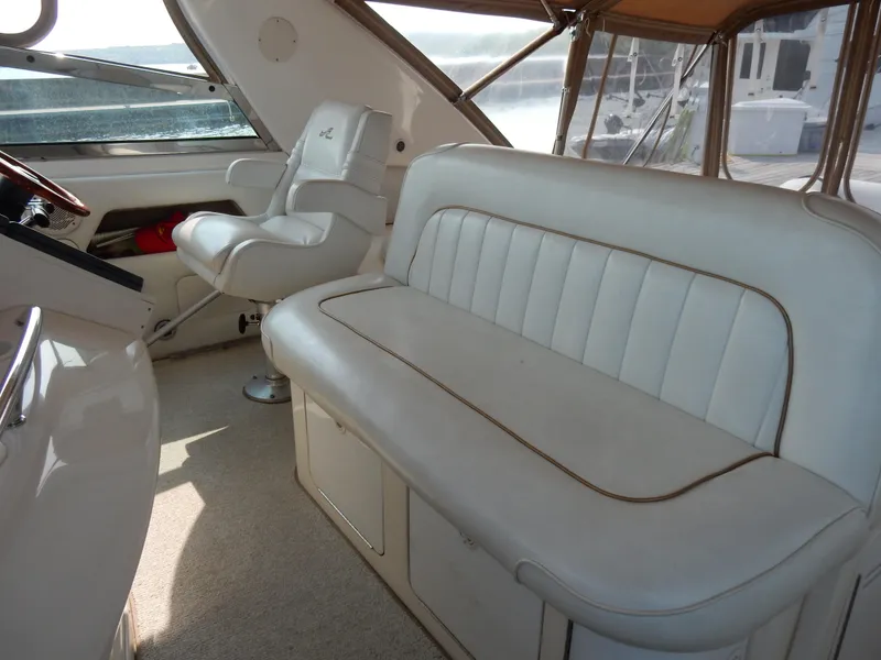Slide: The Image of 1997 Sea Ray 450 yacht interior with white leather seating and helm chair. - 13