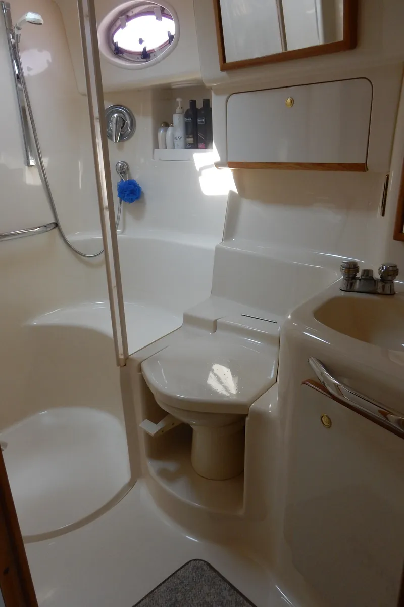 Slide: The Image of Bathroom interior of 1997 Sea Ray 450 yacht, featuring shower, sink, and toilet. - 23
