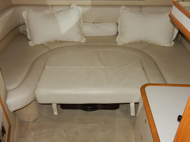 Slide: The Image of 1997 Sea Ray 450 interior with beige leather seating and white cushions. - 26