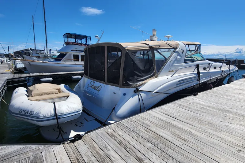 Slide: The Image of 1997 Sea Ray 450 yacht docked with inflatable boat, under clear blue sky. - 3