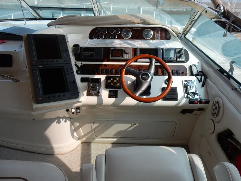 Slide: The Image of 1997 Sea Ray 450 yacht helm with wooden steering wheel and navigation instruments. - 32