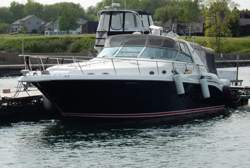 Slide: The Image of 1997 Sea Ray 450 yacht docked in a marina, surrounded by calm water and greenery. - 4