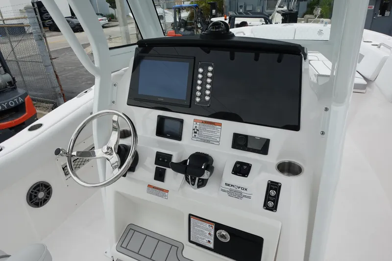 Slide: The Image of 2025 Sea Fox 268 Commander boat dashboard with steering wheel and navigation controls. - 1