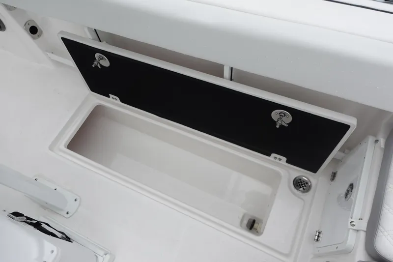Slide: The Image of 2025 Sea Fox 268 Commander boat storage compartment, open with black lid and white interior. - 11