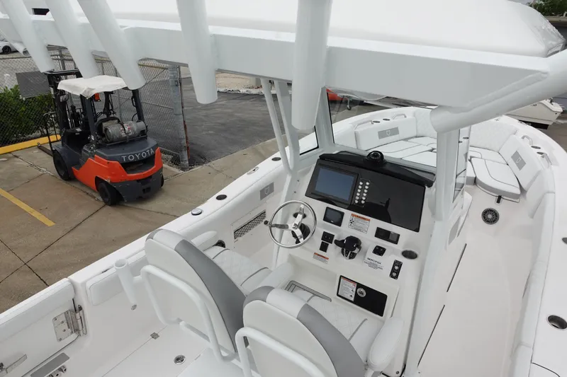 Slide: The Image of 2025 Sea Fox 268 Commander boat interior with modern controls, docked near a forklift. - 13