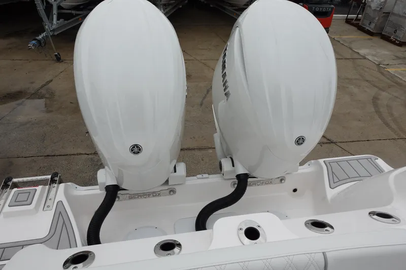 Slide: The Image of 2025 Sea Fox 268 Commander boat with dual outboard engines, docked on concrete surface. - 31