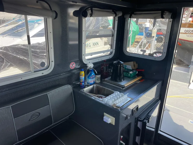 Slide: The Image of Interior of a 2018 Duckworth 28 Offshore boat with kitchenette and seating area. - 23