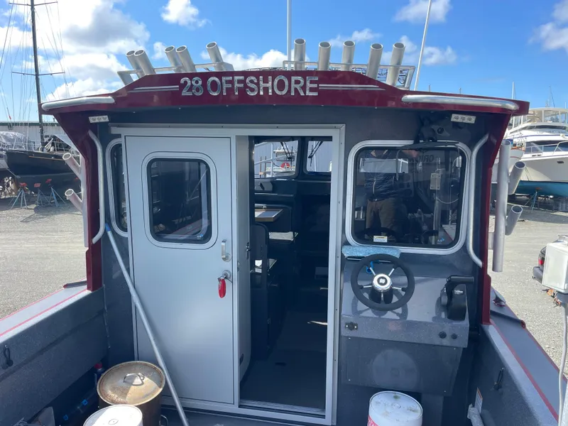 Slide: The Image of 2018 Duckworth 28 Offshore boat with cabin, steering wheel, and fishing rod holders. - 33